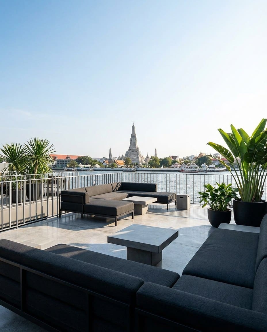 Private riverside terrace looking directly across the Chao Phraya at the spires of Wat Arun in daylight