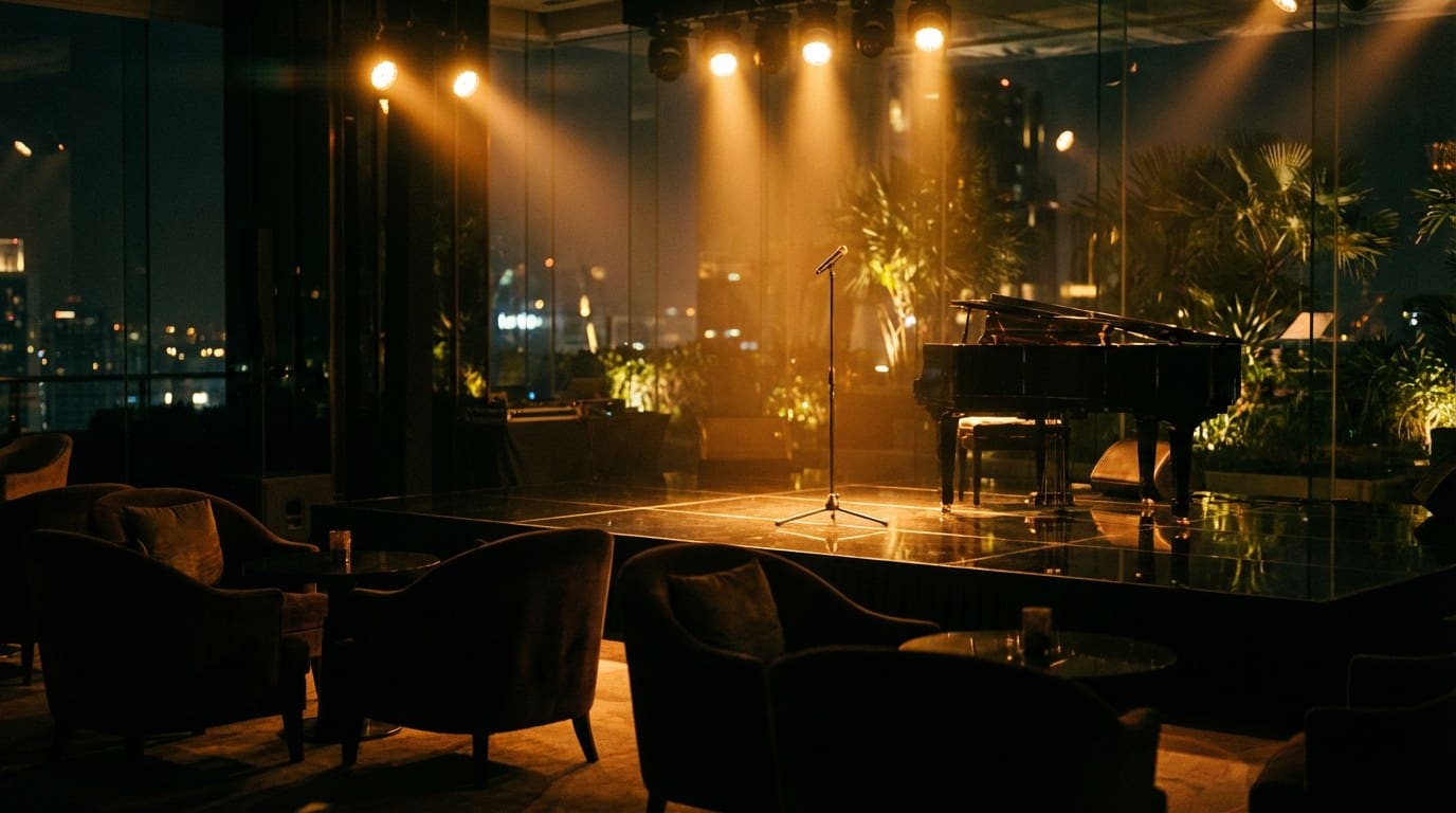 Editorial photograph of a private VIP event stage in a Bangkok luxury venue at night, warm amber stage lighting reflecting on a polished black floor, intimate seating in shadow, anamorphic ultrawide framing.